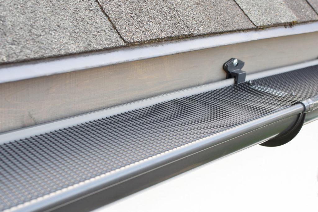 Plastic guard over new dark grey plastic rain gutter